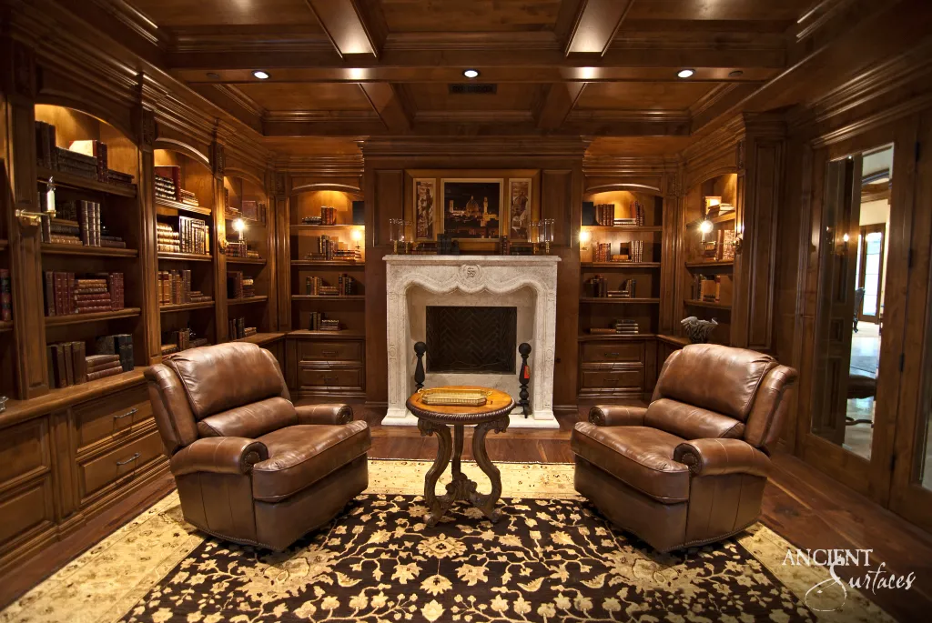 Carved limestone fireplace mantel with a herringbone firebrick firebox in a wood paneled library